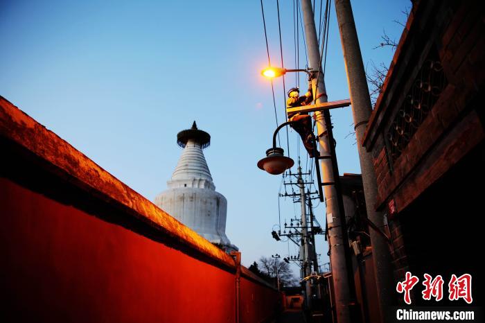 元旦前夕，北京城市照明管理中心員工檢修維護白塔寺等地區(qū)照明設施?！埑?攝