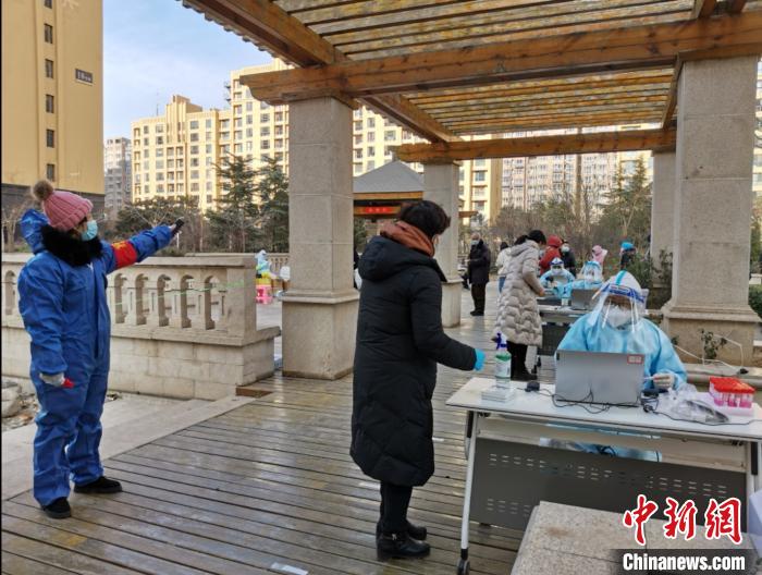圖為社區(qū)工作人員在維持秩序?！∏谌A 攝