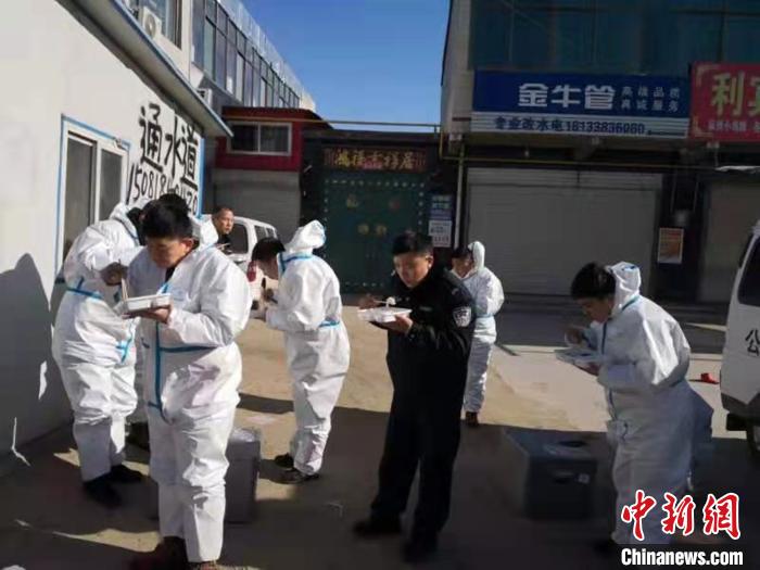 圖為藁城區(qū)增村鎮(zhèn)小果莊村疫情防控檢查站警員為暖和在陽光下吃飯?！堅露Y 攝