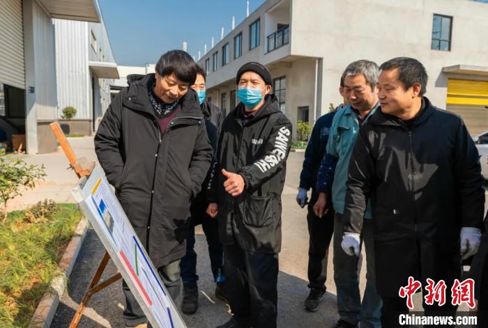 員工圍在展板前了解就地過年相關(guān)政策。婺城宣傳部供圖