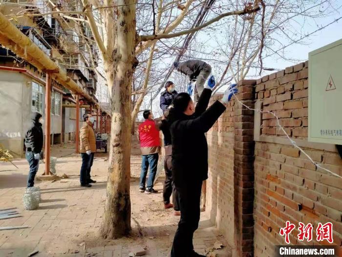 圖為小區(qū)志愿者為小區(qū)圍墻加裝倒刺鐵網(wǎng)?！〈迺?huì)芹 攝