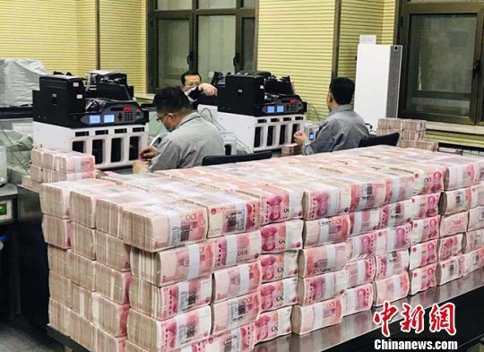 資料圖：銀行點(diǎn)鈔員在工作。艾慶龍 攝
