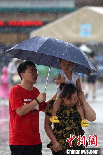 市民冒雨前行?！°蟛?攝