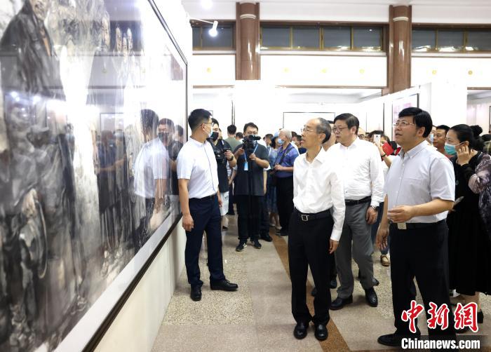 全國人大常委會(huì)副委員長、民革中央主席萬鄂湘等出席開幕式人士參觀展覽作品?！∶窀镏醒牍﹫D