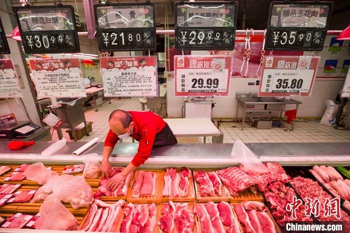 資料圖：一超市內(nèi)，工作人員在整理待售豬肉。 <a target='_blank' href='http://www.chinanews.com/'>中新社</a>記者 張?jiān)?攝