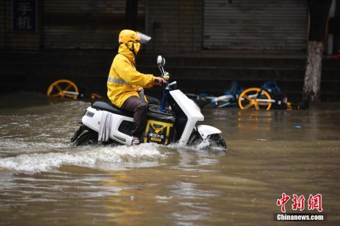 資料圖：外賣小哥通過(guò)積水路段。<a target='_blank' href='http://www.chinanews.com/'>中新社</a>記者 劉冉陽(yáng) 攝
