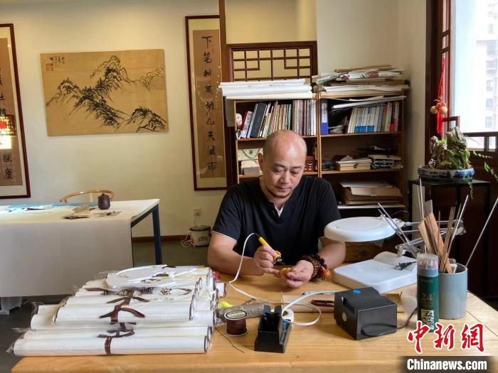 陶思俊正在進(jìn)行葫蘆烙畫(huà)創(chuàng)作。　陳靜 攝