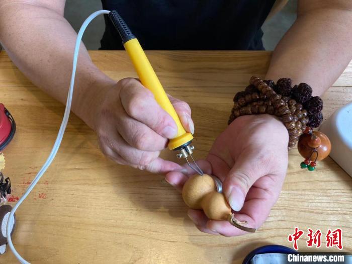 陶思俊正在進(jìn)行葫蘆烙畫(huà)創(chuàng)作?！￡愳o 攝