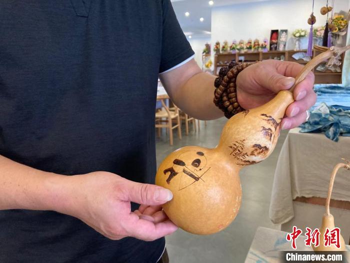 陶思俊展示自己創(chuàng)作的葫蘆烙畫(huà)?！￡愳o 攝