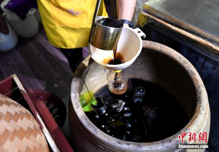 圖為工人將做好的醬油進(jìn)行罐裝。 王東明 攝