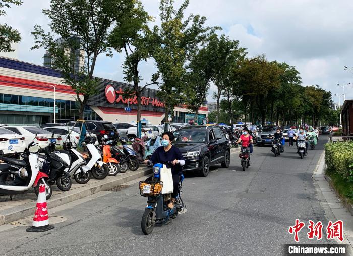 揚(yáng)州一超市門口的人行道也停滿了電動(dòng)車。　崔佳明 攝