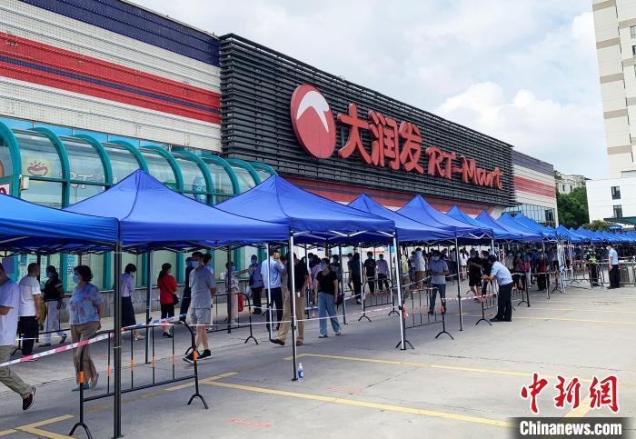 民眾排著長(zhǎng)長(zhǎng)的隊(duì)伍，在工作人員的指引下，等待進(jìn)入超市購(gòu)物?！〈藜衙?攝