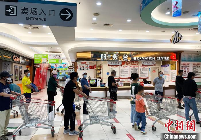 民眾戴著口罩，有序排隊(duì)，等待進(jìn)入超市購(gòu)物?！〈藜衙?攝