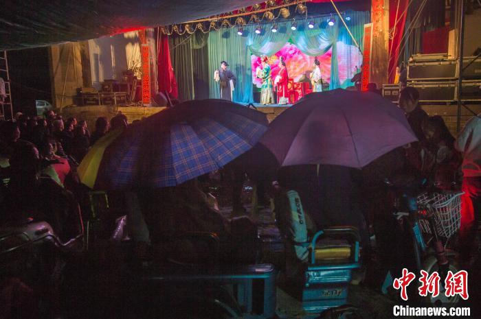 民眾在雨中觀看蒲劇?！∥淇〗?攝