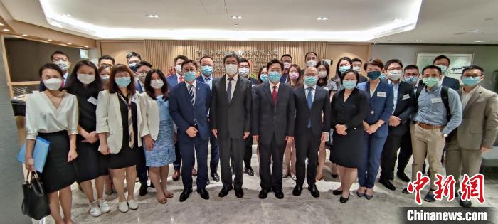 香港中聯(lián)辦秘書長王松苗一行與“港漂”律師們合影?！∠愀壑新?lián)辦供圖