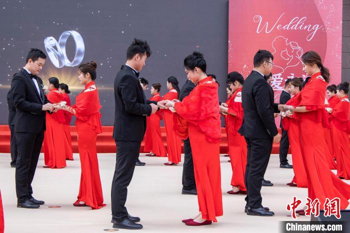 圖為新人們在集體婚禮現(xiàn)場交換婚戒。　王威 攝