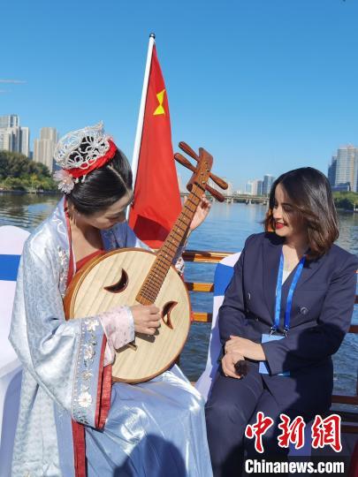 迪拜中阿衛(wèi)視記者伊曼(右)“討教”如何彈上一曲“千古絕唱”。　<a target='_blank' href='http://www.chinanews.com/'>中新社</a>記者 盛佳鵬 攝