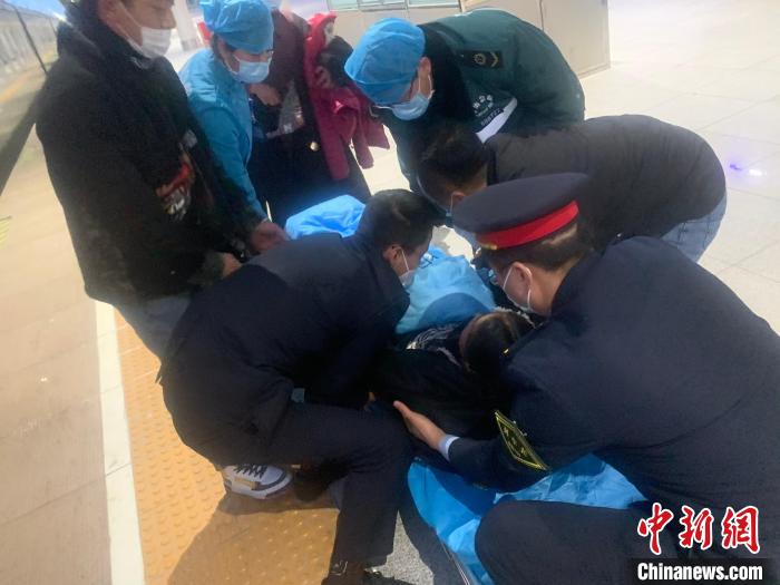 圖為車站工作人員與120急救人員將孕婦抬上擔(dān)架。　青藏集團公司供圖