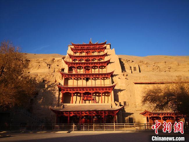 圖為2020年11月7日，晨光沐浴中的莫高窟標(biāo)志性建筑“九層樓”。(資料圖)