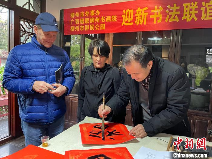 柳州市一書法家教兩位英國人書寫春聯(lián)。　林馨 攝