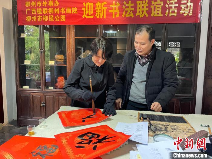圖為一名英國人體驗(yàn)寫春聯(lián)?！×周?攝