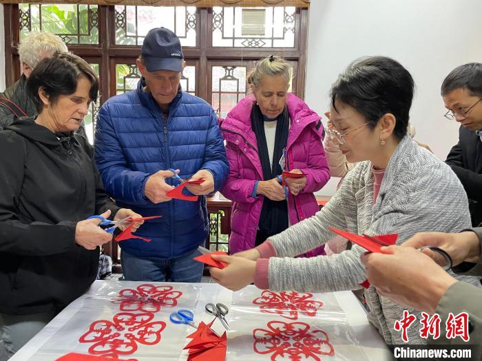 圖為外國友人體驗(yàn)剪紙?！×周?攝