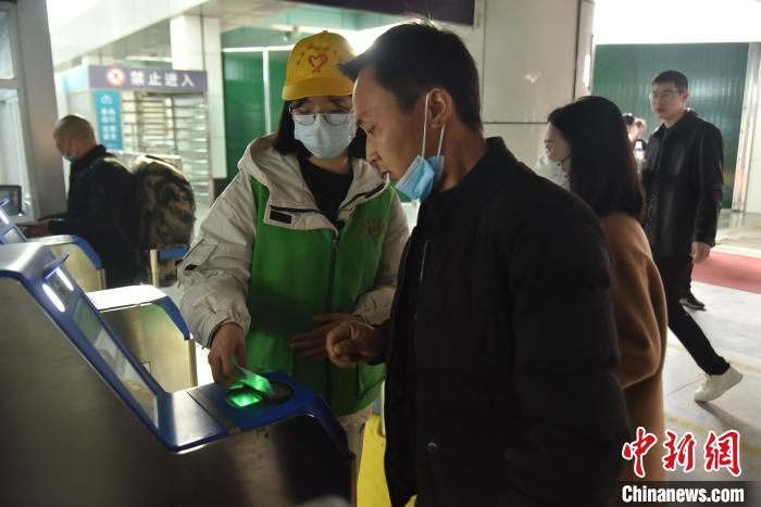 圖為志愿者協(xié)助乘客?！№n毅 攝