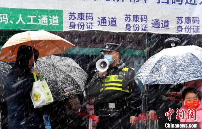7日上午，南京公安干警冒雪值守在人流量較大的地區(qū)，保障行人安全。　國武 攝