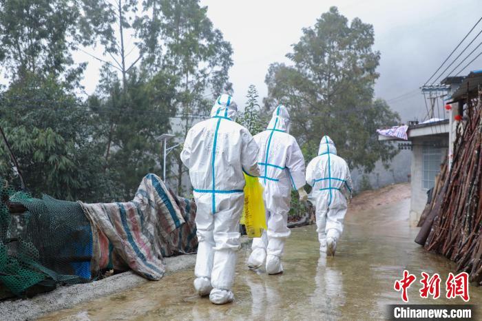 圖為在德?？h隆桑鎮(zhèn)果甫村，身著厚重防護(hù)服的歐秋潔和同伴步履蹣跚地行走。