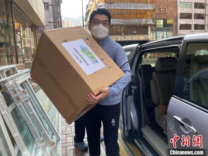 圖為吳學明搬運1200份快速檢測套裝及500多個口罩，捐贈給開平樓崗同鄉(xiāng)會?！∈茉L者供圖