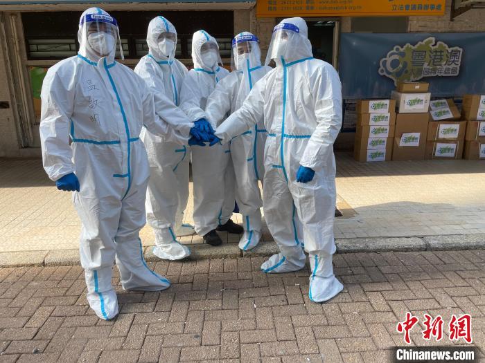 圖為吳學明(右一)等人穿著防護服來到前線協(xié)助全港抗疫?！∈茉L者供圖