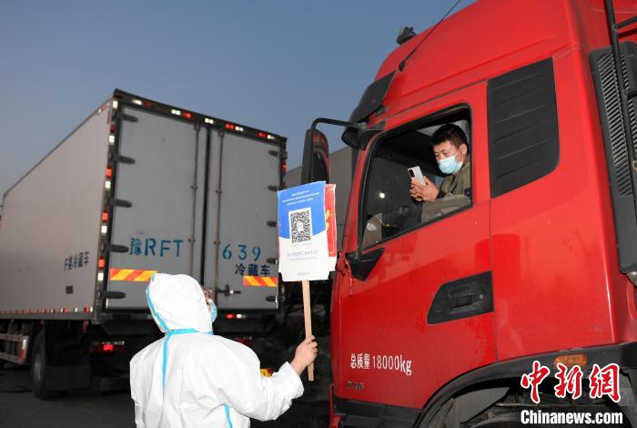 工作人員舉牌讓貨車(chē)司機(jī)掃碼。　王剛 攝