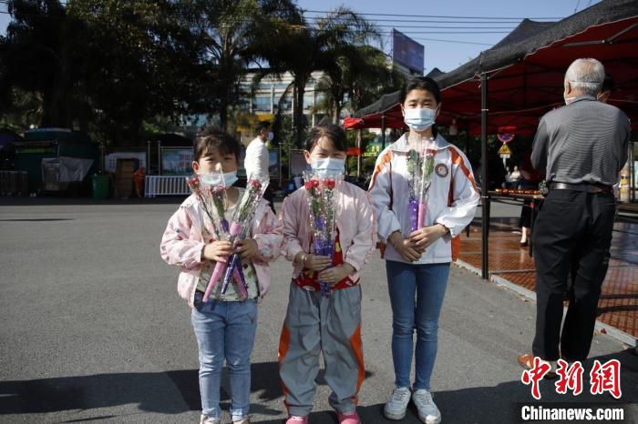 小朋友走出家門領(lǐng)取康乃馨。　陳雅芳 攝