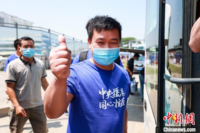 建設(shè)者們身穿文化衫，帶著燦爛的笑容離開(kāi)駐地?！≠Z凱 攝