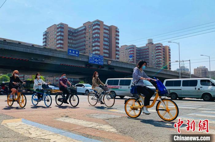 5日，北京東三環(huán)附近正騎單車出行的市民。