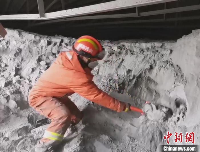 一名消防員單腿跪在粉煤灰堆上搜救被困人員?！↓R帥 攝