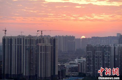 資料圖：城區(qū)一角，太陽(yáng)正從東方升起。<a target='_blank' href='/'>中新社</a>記者 劉忠俊 攝