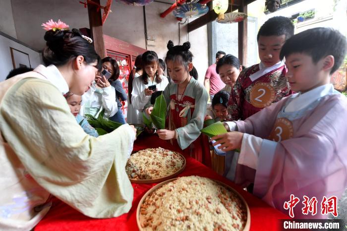 圖為兩岸親自家庭體驗(yàn)釣包粽子?！蚊?攝