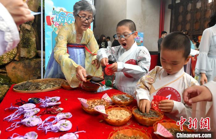 圖為兩岸親自家庭體驗(yàn)包香囊?！蚊?攝