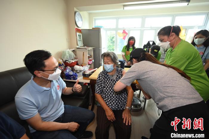 聶德權(quán)(左一)鼓勵一位居于香港坪洲的80多歲長者(左二)接種第二劑新冠疫苗?！∠愀厶貐^(qū)政府新聞處供圖