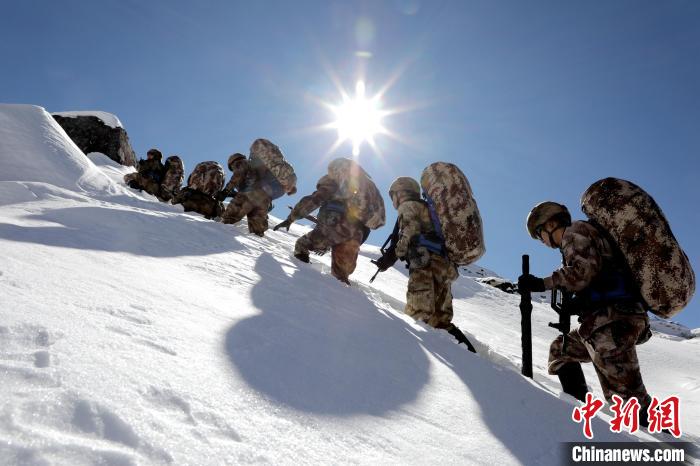 圖為巡邏官兵翻越雪山?！●R軍 攝