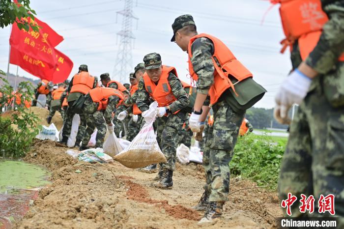 武警江西總隊機動支隊官兵奔赴江西景德鎮(zhèn)市樂平市開展搶險救援，傳遞沙袋。　彭丁 攝