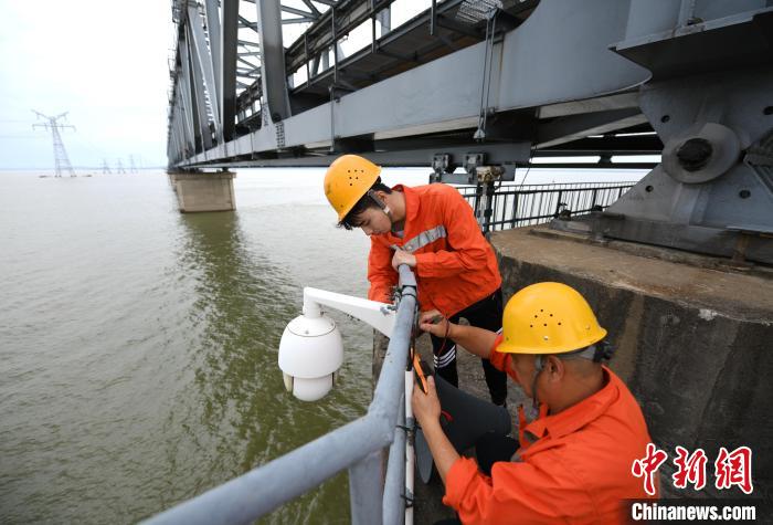 6月24日，南鐵九江橋工段的橋梁工正在九景衢鐵路鄱陽(yáng)湖大橋上對(duì)監(jiān)控?cái)z像頭進(jìn)行檢修?！『鷩?guó)林 攝