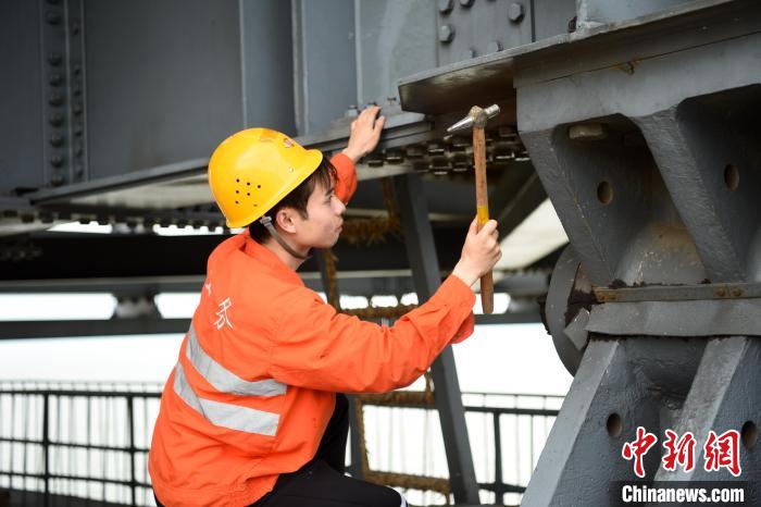 6月24日，南鐵九江橋工段的橋梁工正在九景衢鐵路鄱陽(yáng)湖大橋上對(duì)高強(qiáng)度螺栓進(jìn)行檢查更換?！?黃旸 攝