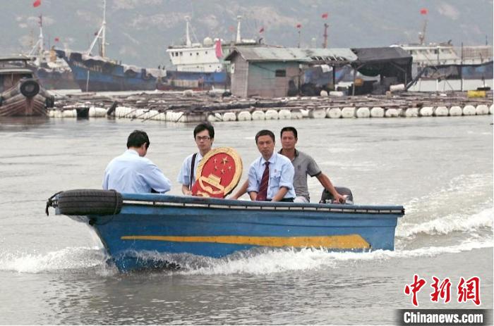 三都海上巡回法庭設(shè)立之初，法官們帶著國徽、坐著快艇，到漁排上審理、調(diào)解案件?！〗冻菂^(qū)法院 供圖