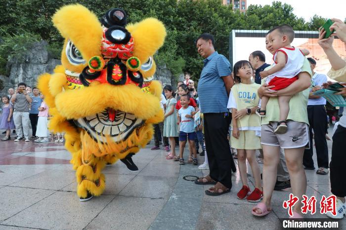 賴翊凡(獅頭)與李洪江配合在縣城詩(shī)鄉(xiāng)廣場(chǎng)練習(xí)舞獅吸引市民觀看?！■暮陚?攝