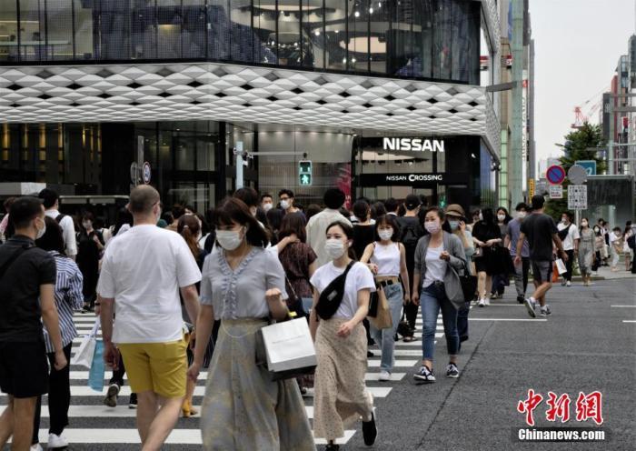 資料圖：日本當(dāng)?shù)孛癖娕宕骺谡肿哌^東京街頭。 <a target='_blank' href='/'>中新社</a>記者 呂少威 攝