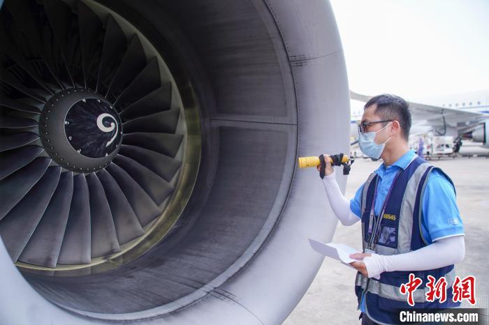 圖為航線維護工程師對飛機發(fā)動機進行檢查。　陳冠言 攝