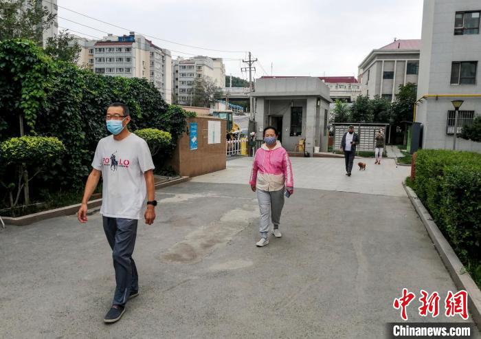 烏魯木齊市沙依巴克區(qū)國道社區(qū)，市民保持距離在小區(qū)內(nèi)散步?！＄娦?攝