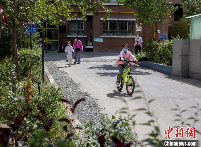 烏魯木齊市水磨溝區(qū)七道灣東街南社區(qū)，居民下樓在小區(qū)內(nèi)活動。　鐘欣 攝